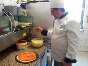 Tychy: Osteria Le Botti. Po posmarowaniu pizzy sosem z włoskich pomidorów, Nunzio posypuje je mozarellą z bawolego mleka